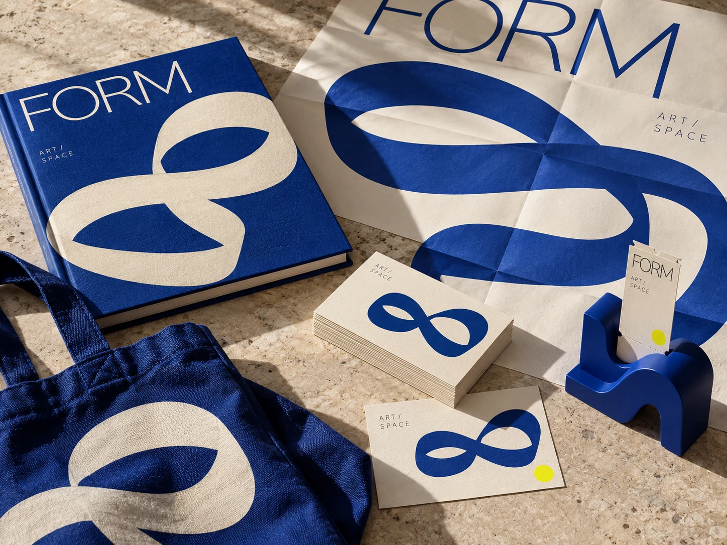 A cobalt and ivory cultural identity applied to exhibition print, a tote and invitations.